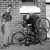 A student fixing a bicycle tyre puncture with another student standing by, circa 1940s