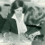 A student in the 1980s cutting fabric in a dressmaking class under teacher supervision