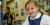 A Primary School students smiles while working at her desk