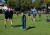 A professional cricketer watches on as a student learns to bowl during a cricket clinic