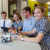 Two students looking at an iPad with the Digital Technologies teacher and another student smiles while controlling a robot