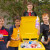 A group of students holding 10 cent recyclables, which have been collected to raise funds for The Mustard Seed Family Project