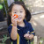 An ELC student holding a freshly picked tomato in the ELC garden
