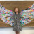 A student standing in front of an artwork made of leaves created by students across a range of year levels