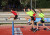 A group of students running a hurdle race at Sports Day
