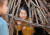 A student smiling while looking out from inside a structure made of fallen sticks at ELC Bush Day