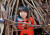 A student looking out from inside a structure constructed from fallen sticks on ELC Bush Day