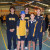 A group of students standing in the gym and smiling while their peers continue with the Walk Our Way event