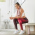 Kayla Itsines sitting on a bench seat in a bright, modern indoor space